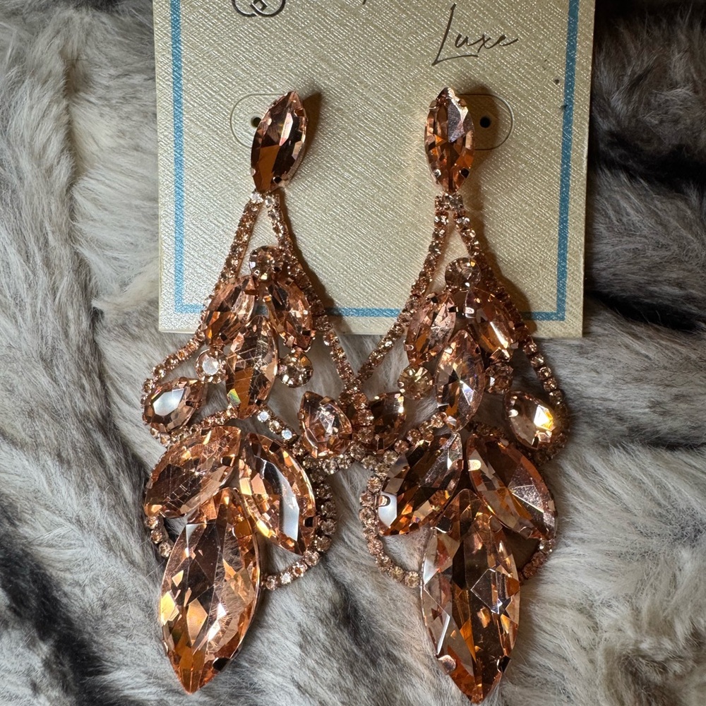 Rose gold champagne pink colored dangly diamond earrings.